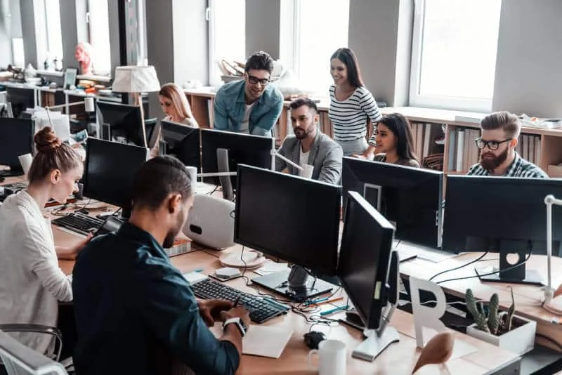 Desarrolladores trabajando con monitores en una oficina compartida